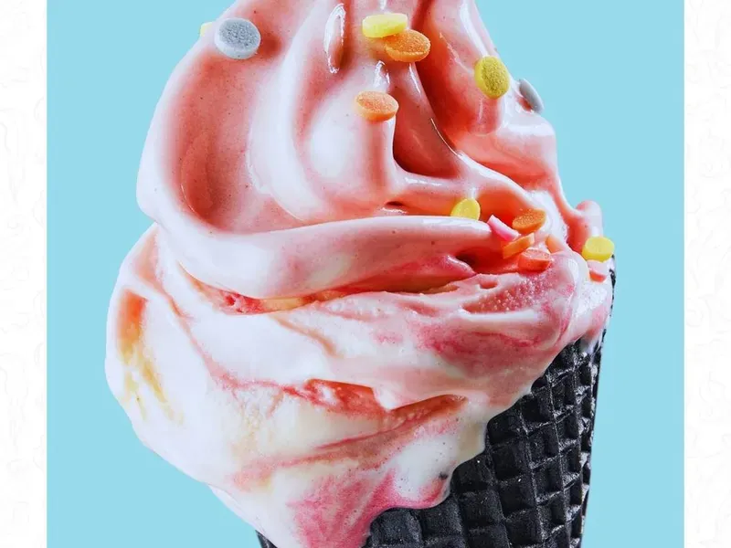 Soft ice cream merah muda di cone hitam